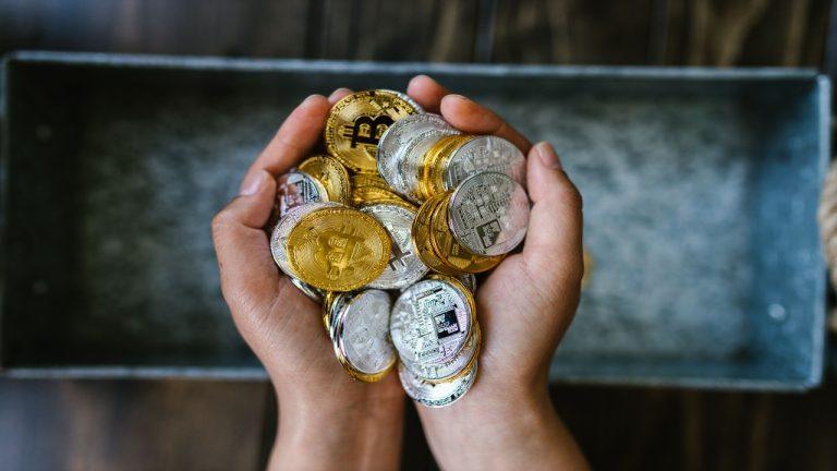 Image showing a person with many physical Bitcoin tokens in their hand.